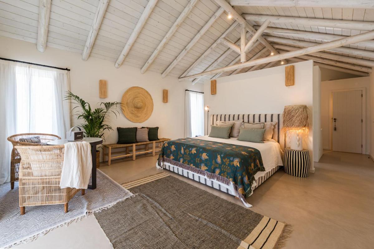 um quarto com uma cama e um sofá em uma sala em Independente Comporta na Comporta
