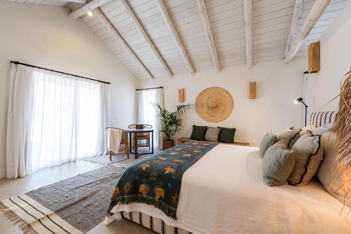 um quarto com uma cama grande e uma janela grande em Independente Comporta na Comporta mais 137 fotografias