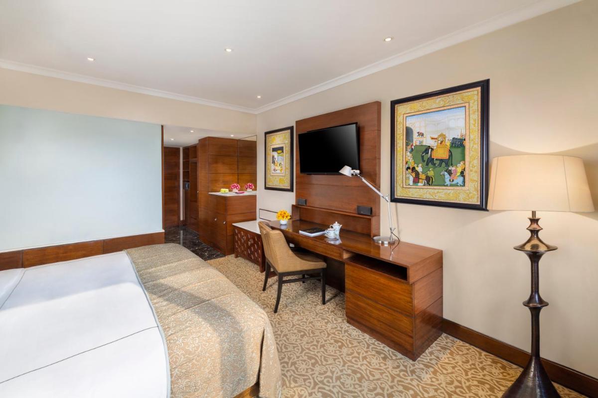 a hotel room with a bed and a desk and a television at Taj Palace, New Delhi in New Delhi a hotel room with a bed and a desk and a television at Taj Palace, New Delhi in New Delhi