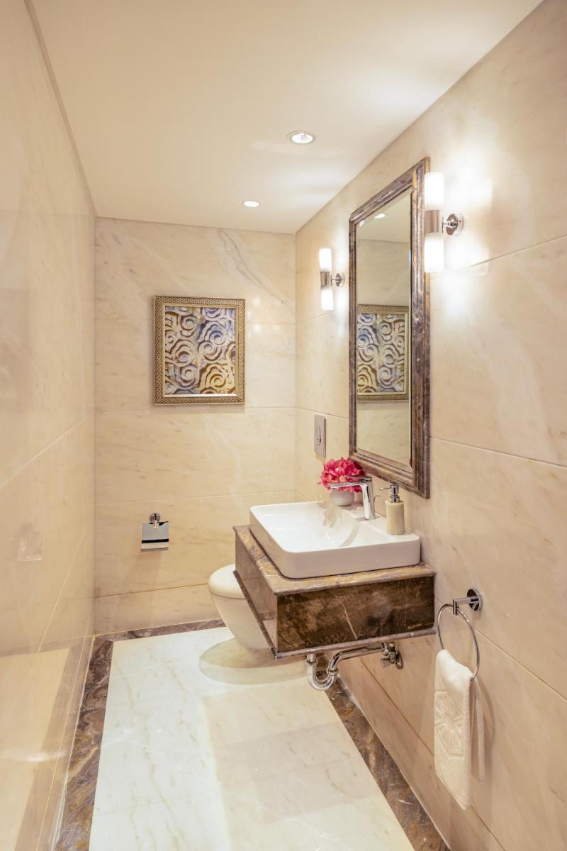 a bathroom with a sink and a toilet and a mirror at Taj Palace, New Delhi in New Delhi a bathroom with a sink and a toilet and a mirror at Taj Palace, New Delhi in New Delhi