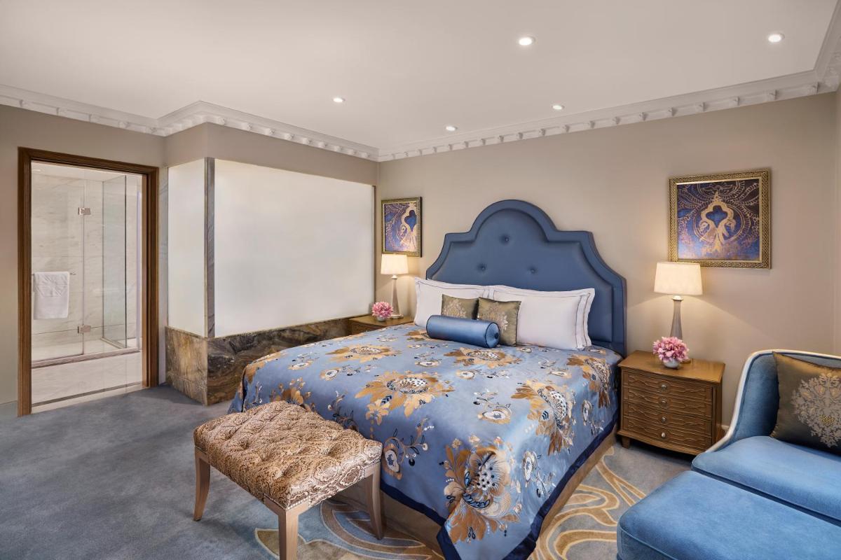 a large bedroom with a blue bed and a chair at Taj Palace, New Delhi in New Delhi a large bedroom with a blue bed and a chair at Taj Palace, New Delhi in New Delhi