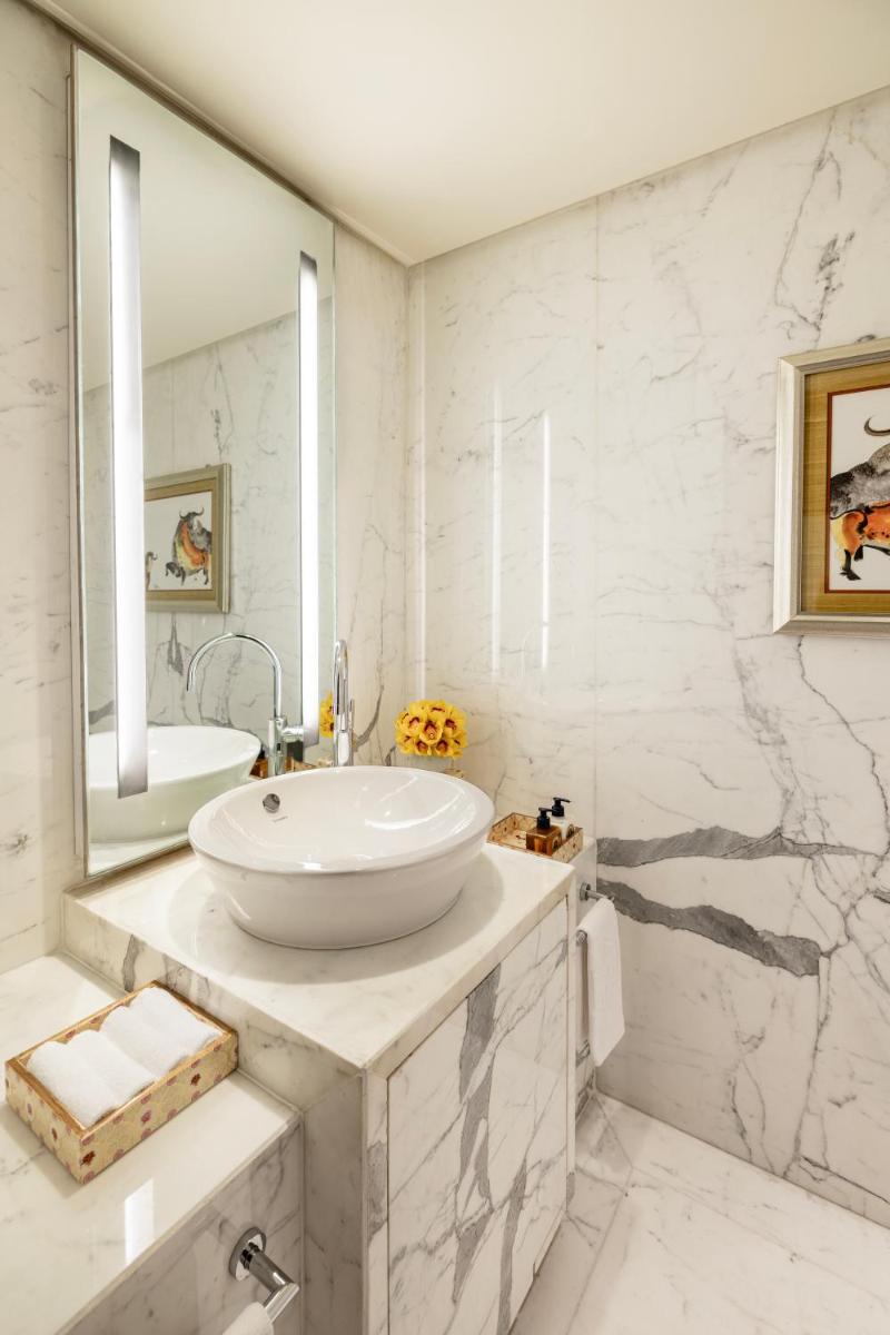 a white bathroom with a sink and a mirror at Taj Palace, New Delhi in New Delhi a white bathroom with a sink and a mirror at Taj Palace, New Delhi in New Delhi