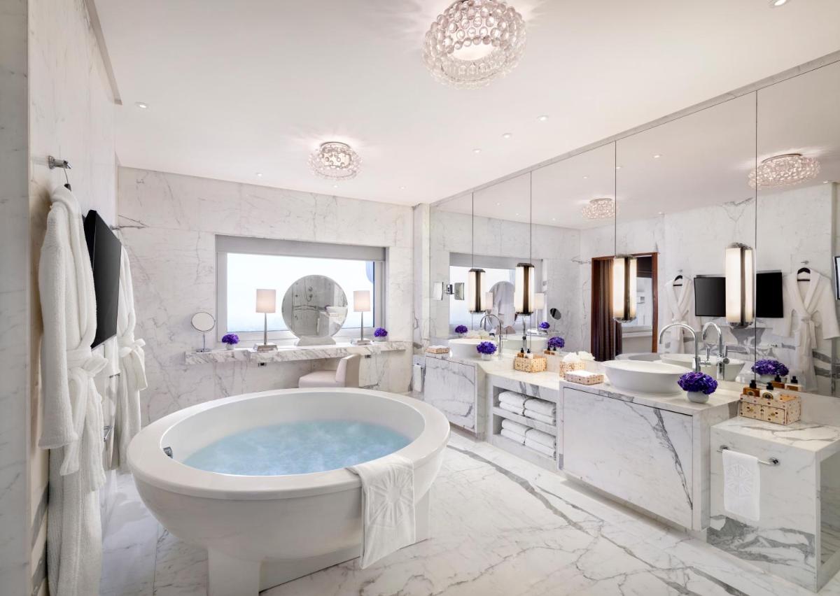 a white bathroom with a tub and a sink at Taj Palace, New Delhi in New Delhi a white bathroom with a tub and a sink at Taj Palace, New Delhi in New Delhi