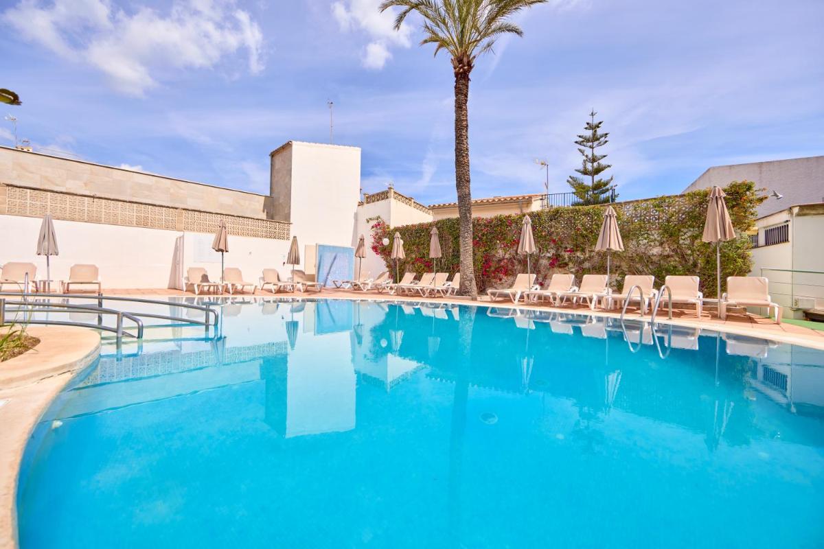 una gran piscina con sillas y sombrillas en Ilusion Markus & Spa, en Can Picafort
