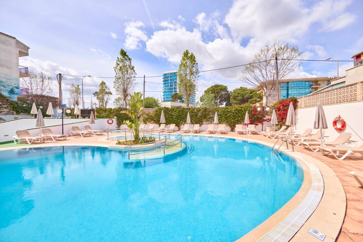 una gran piscina con sillas y sombrillas en Ilusion Markus & Spa, en Can Picafort