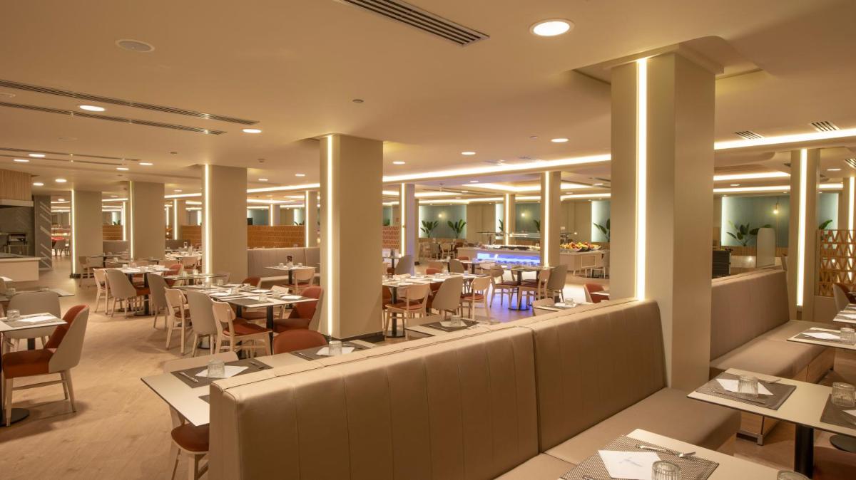 Un restaurante con mesas y sillas y un bar. en Gran Hotel Bali & Spa, en Benidorm