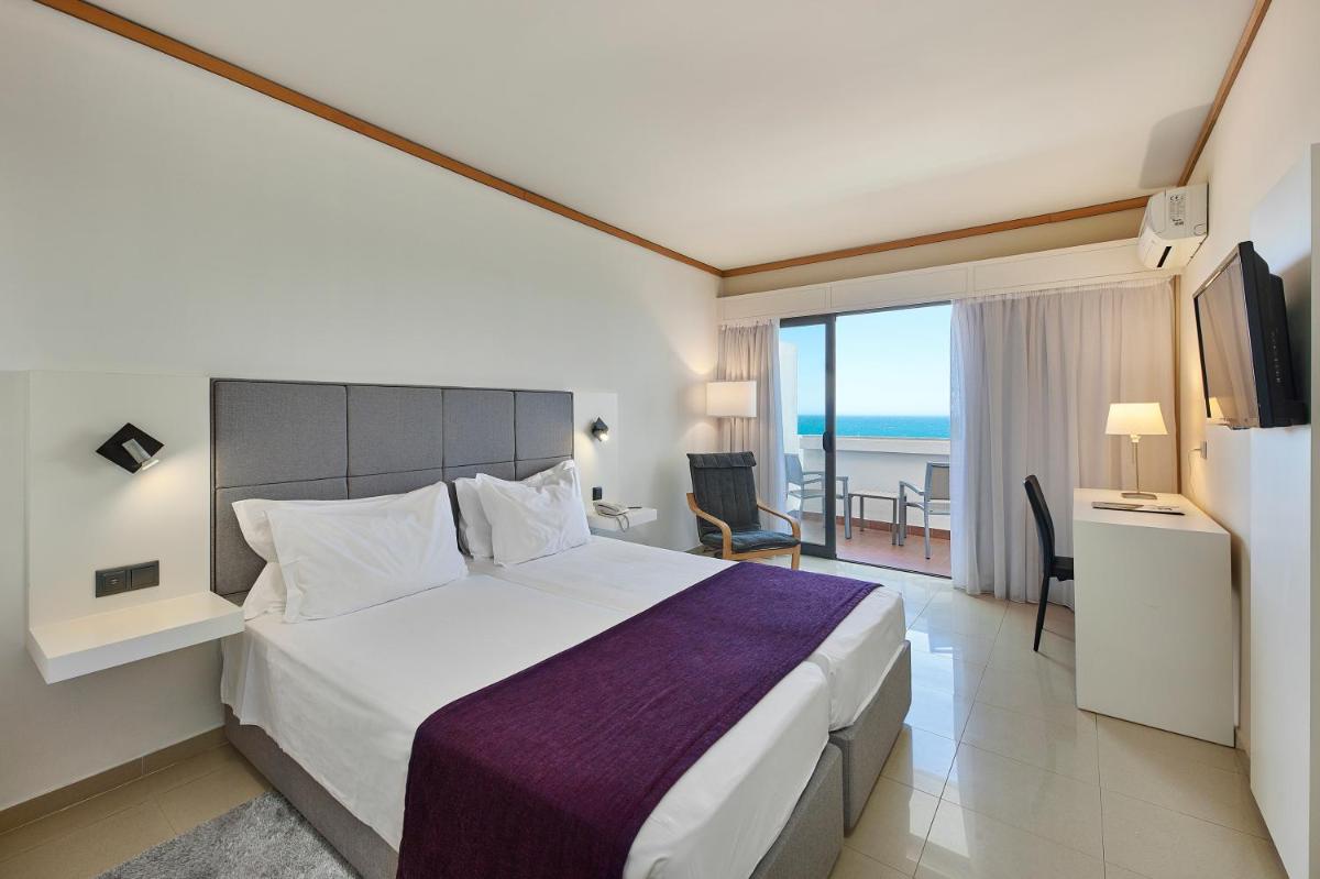 um quarto de hotel com uma cama e vista para o oceano em Rocamar Exclusive Hotel & Spa - Adults Only em Albufeira mais 118 fotografias