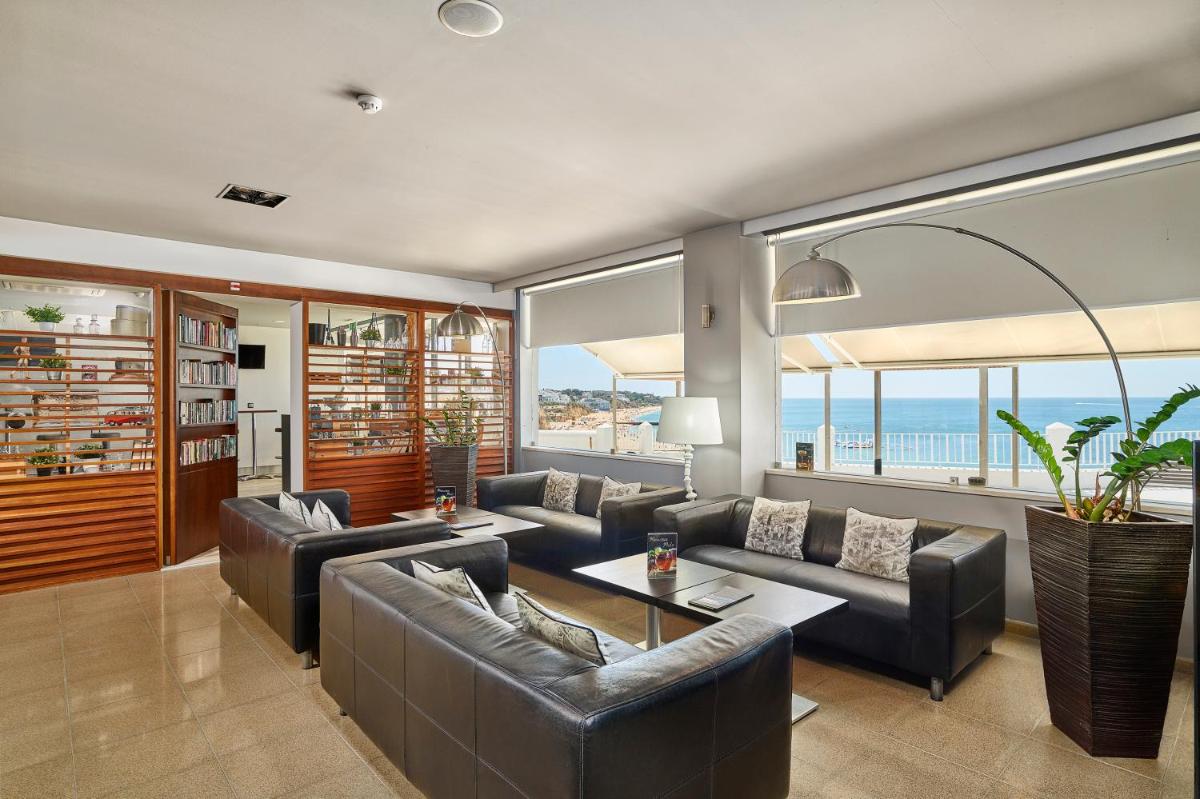 uma sala de estar com sofás e uma mesa em Rocamar Exclusive Hotel & Spa - Adults Only em Albufeira