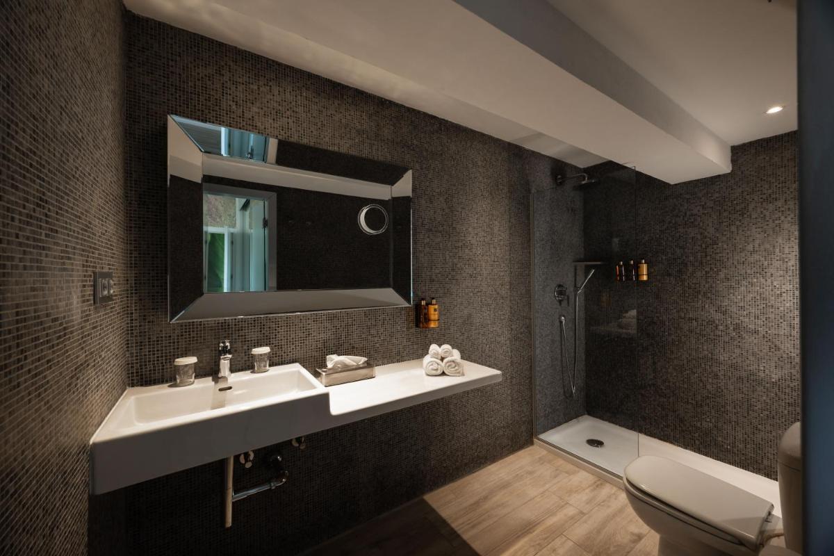 Un baño con lavabo, espejo e inodoro. en Ibiza Corso Hotel & Spa, en Ibiza
