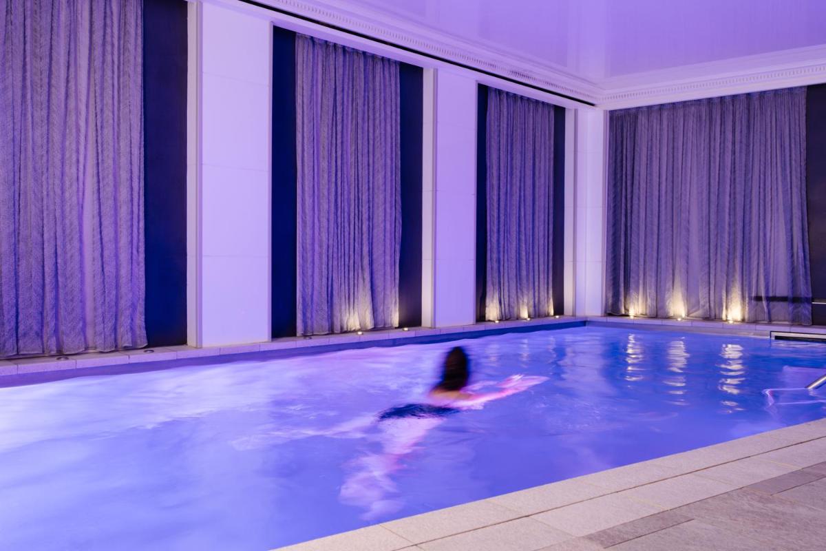 une personne nageant dans une piscine dans un immeuble dans l'établissement La Villa Haussmann, à Paris