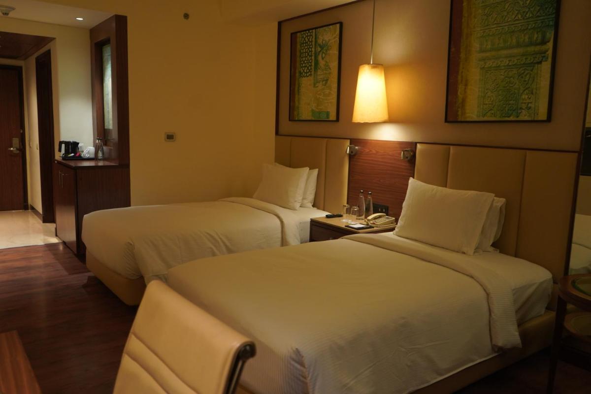 a hotel room with two beds and a table at DoubleTree by Hilton Agra in Agra