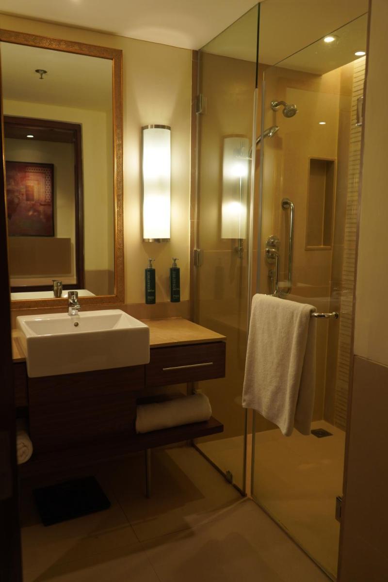 a bathroom with a sink and a shower with a mirror at DoubleTree by Hilton Agra in Agra