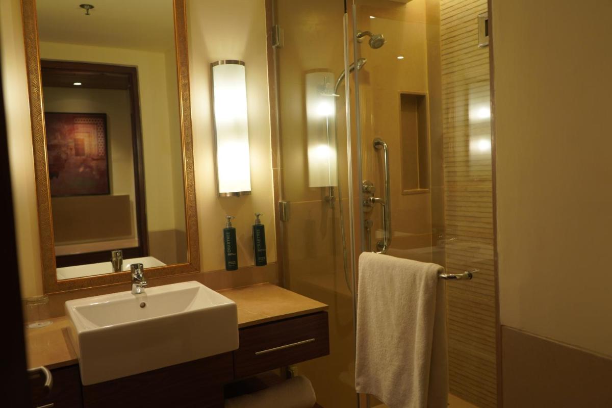 a bathroom with a sink and a shower with a mirror at DoubleTree by Hilton Agra in Agra