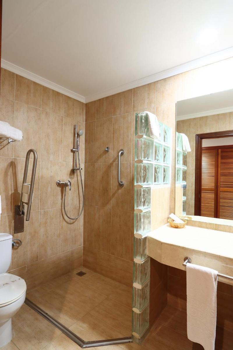 Un baño con ducha, inodoro y lavabo. en Hotel Varinia Serena - Balneario de Alange, en Alange