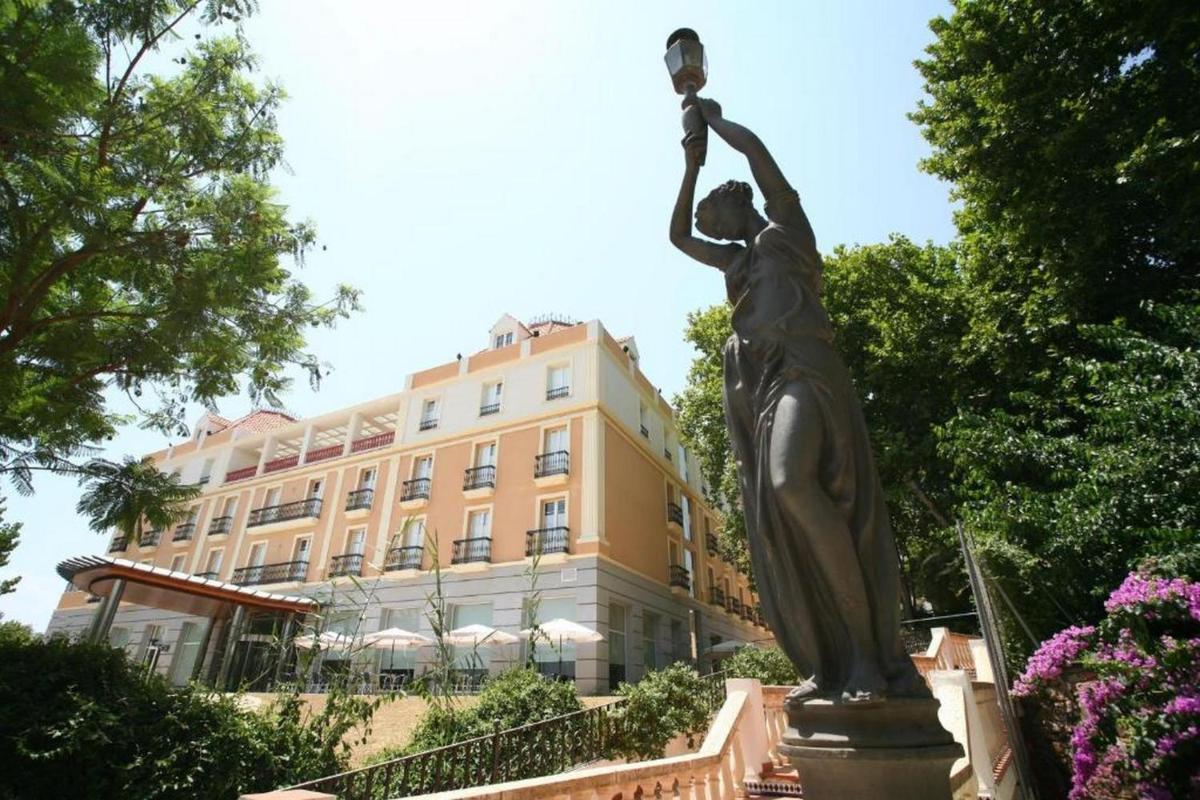 Una estatua de una mujer parada frente a un edificio. en Gran Hotel Aqualange - Balneario de Alange, en Alange