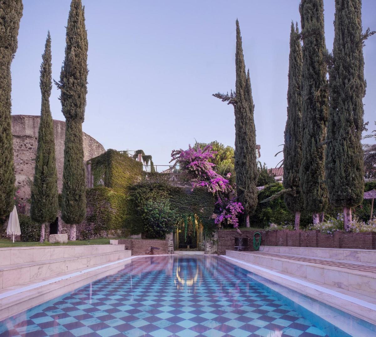 una piscina en un jardín con árboles en Hotel Varinia Serena - Balneario de Alange, en Alange