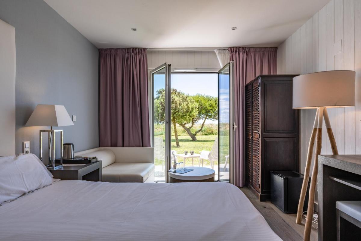 une chambre d'hôtel avec un lit et un salon dans l'établissement Hôtel Atalante - Relais Thalasso & Spa, à Sainte-Marie de Ré