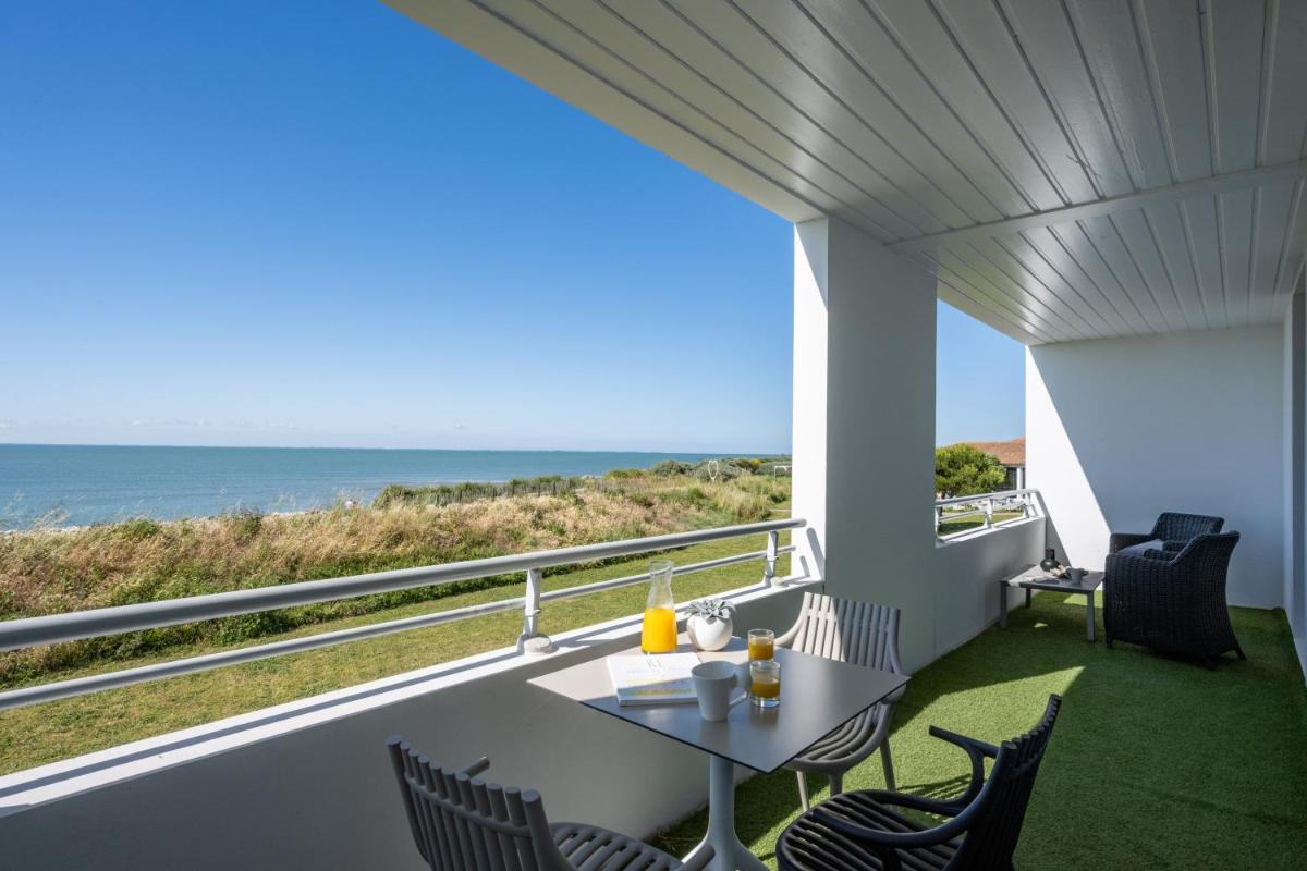 un balcon avec une table et des chaises et l'océan dans l'établissement Hôtel Atalante - Relais Thalasso & Spa, à Sainte-Marie de Ré