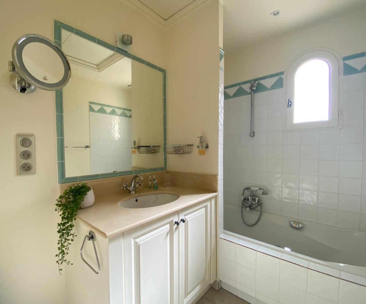 une salle de bain avec un lavabo, une douche et un miroir dans l'établissement Les Appartements et Maisons du Domaine de Saint Endréol Golf & Spa Resort, à La Motte