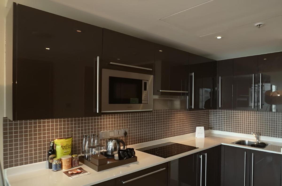 a kitchen with black cabinets and a counter top at Hilton Bangalore Embassy GolfLinks in Bengaluru