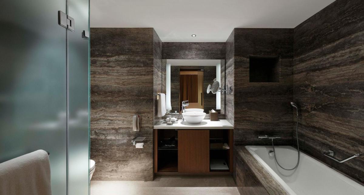 a bathroom with a tub and a sink and a shower at Hilton Bangalore Embassy GolfLinks in Bengaluru