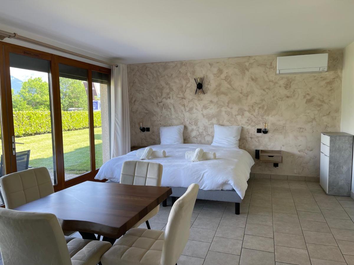 une chambre avec un lit, une table et des chaises dans l'établissement La Parenthèse Enchantée, à Sévrier