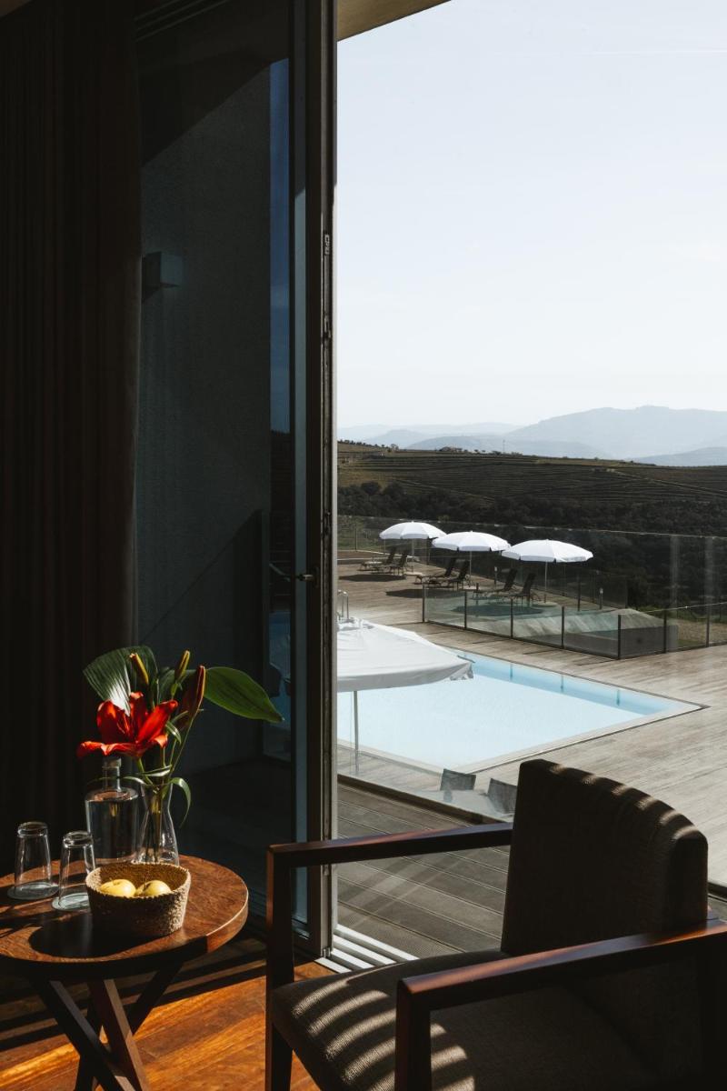 um quarto com uma mesa e vista para uma piscina em Douro Scala em Mesão Frio
