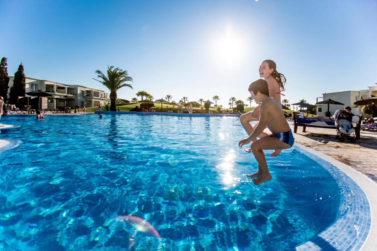 un niño y una niña jugando en una piscina en Vincci Resort Costa Golf, en Chiclana de la Frontera