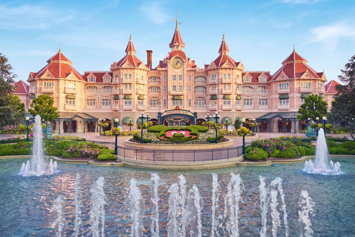 un grand bâtiment avec une fontaine devant dans l'établissement Disneyland® Hotel, à Chessy