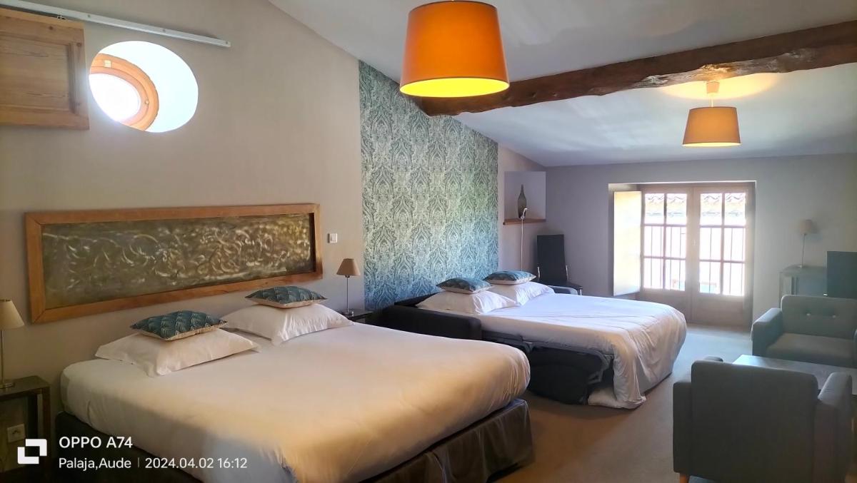 une chambre d'hôtel avec deux lits et une chaise dans l'établissement Logis Hôtel Château De Palaja, à Carcassonne 257 autres photos