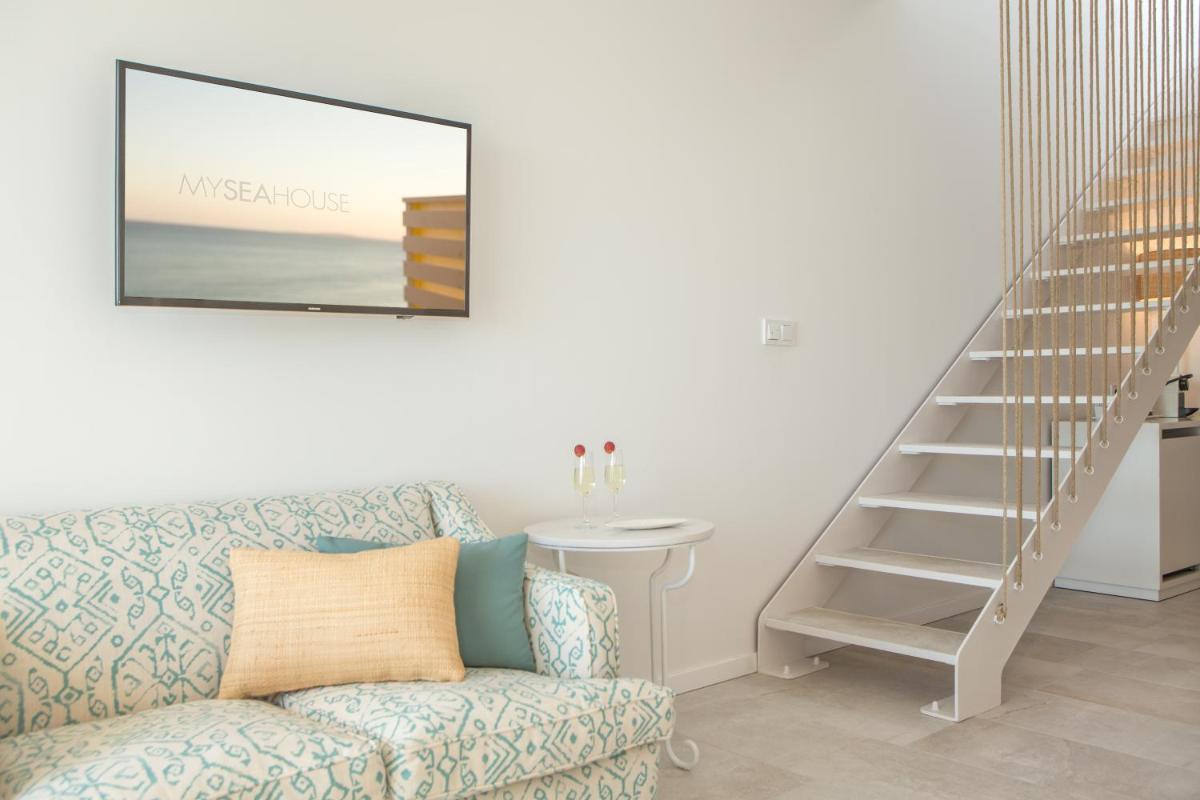 Una sala de estar con un sofá y una escalera. en Myseahouse Flamingo - Adults Only 4* Sup, en Playa de Palma