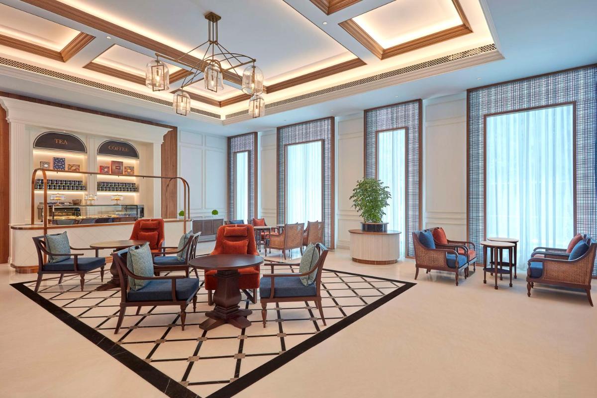 a lobby with chairs and a table in a room at Doubletree By Hilton Bengaluru Whitefield in Bengaluru