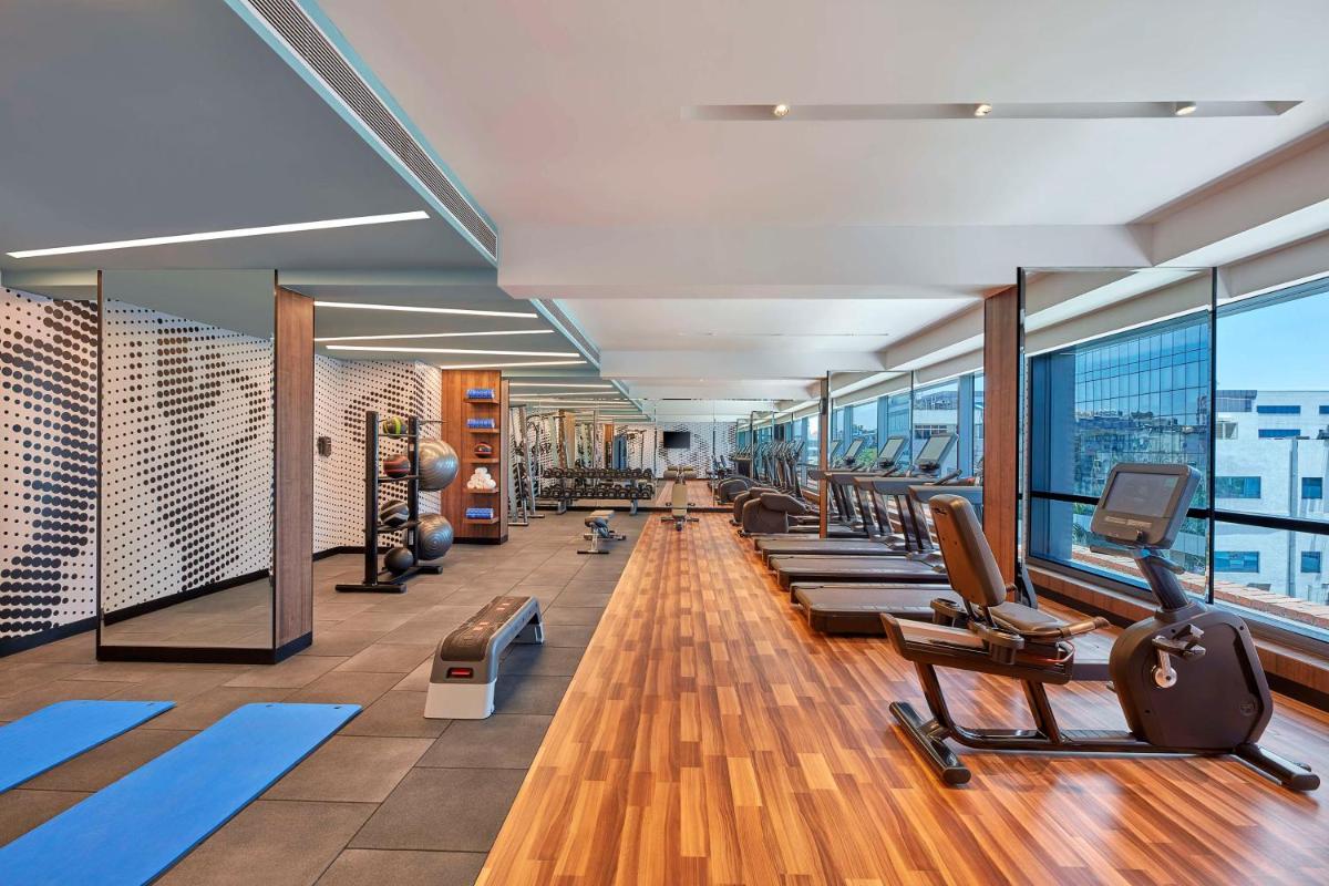 a gym with a row of treadmills and exercise equipment at Doubletree By Hilton Bengaluru Whitefield in Bengaluru