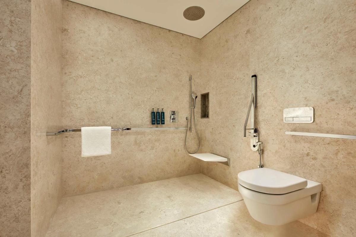 a bathroom with a toilet and a sink at Doubletree By Hilton Bengaluru Whitefield in Bengaluru