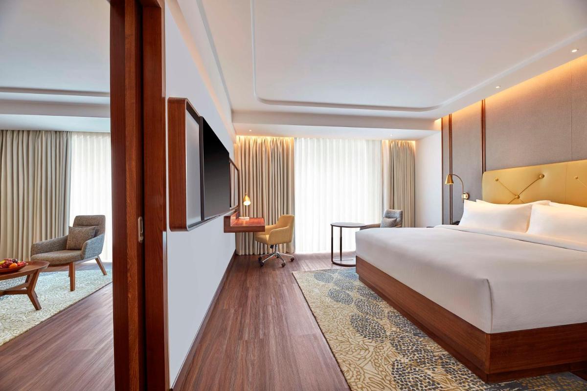 a hotel room with a bed and a television at Doubletree By Hilton Bengaluru Whitefield in Bengaluru