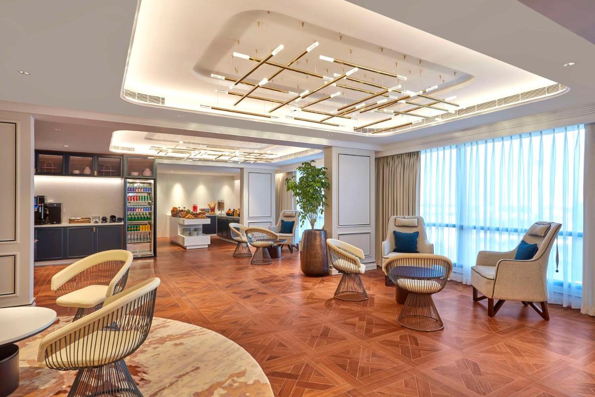 a living room with chairs and tables and a lobby at Doubletree By Hilton Bengaluru Whitefield in Bengaluru