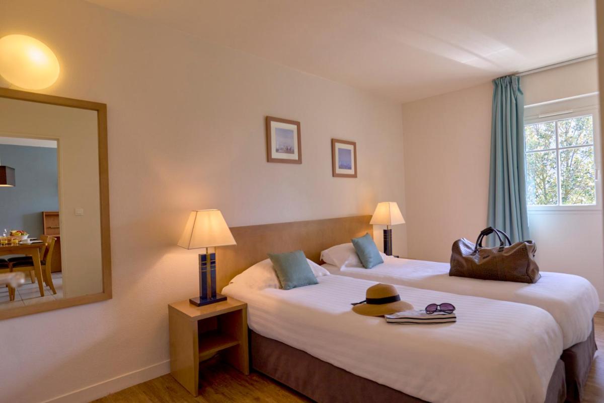 une chambre d'hôtel avec deux lits et un miroir dans l'établissement Residence Reine Marine, à Saint-Malo