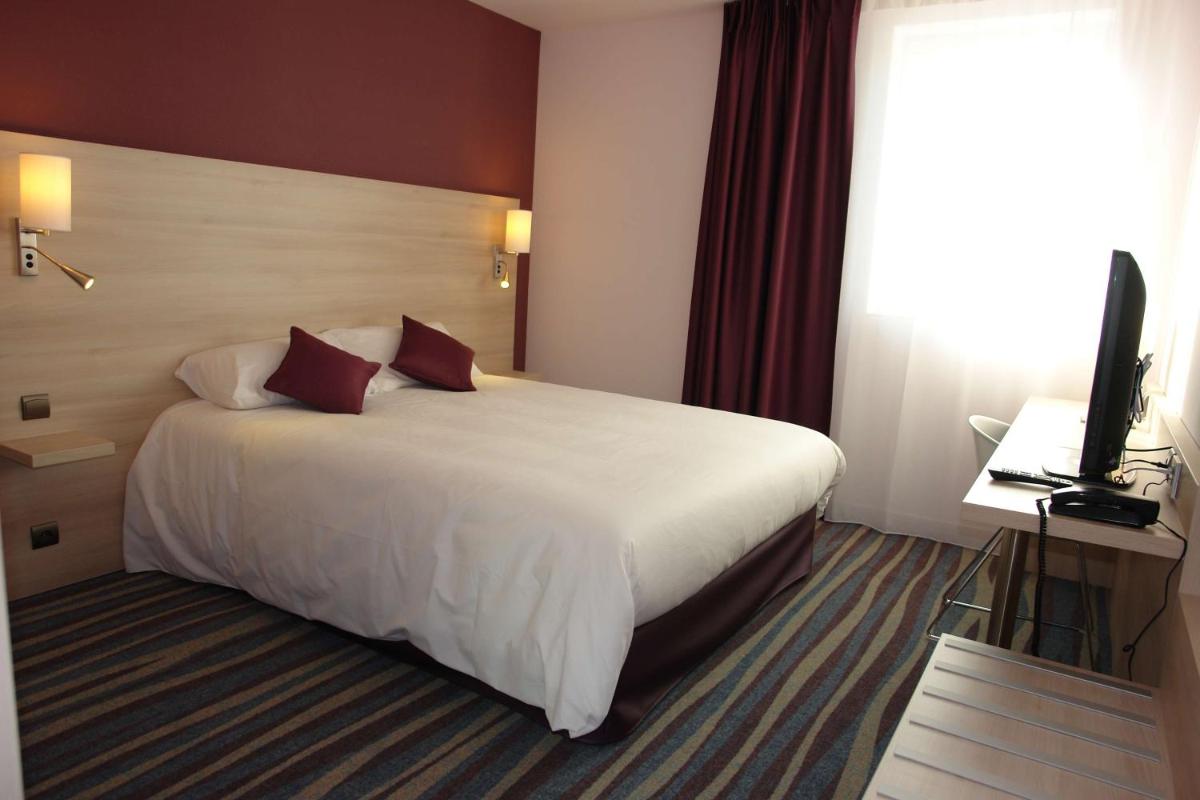Un ou plusieurs lits dans un hébergement de l'établissement Brit Hotel Vendée Mer