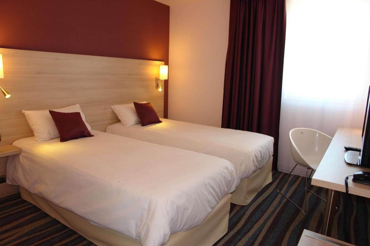 Un ou plusieurs lits dans un hébergement de l'établissement Brit Hotel Vendée Mer