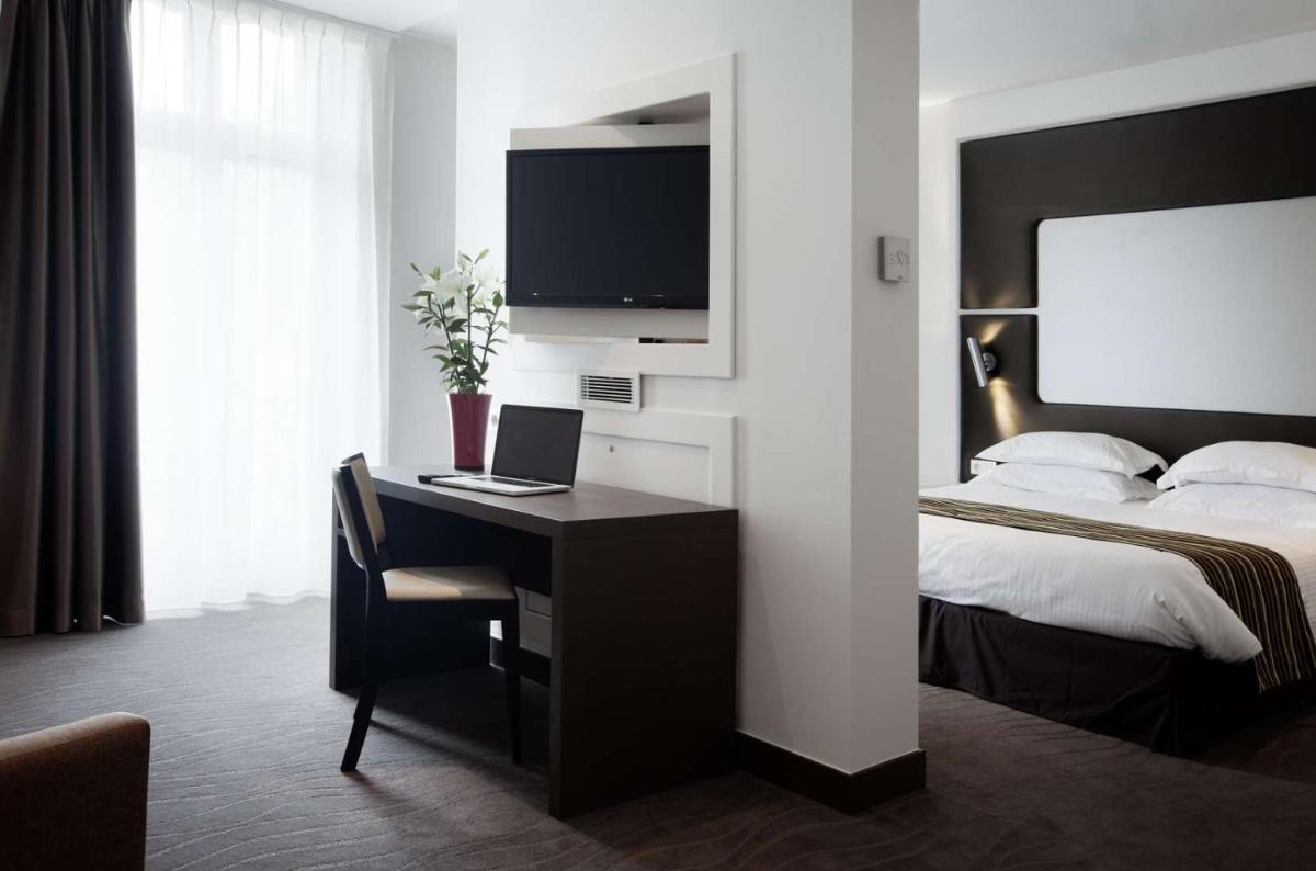 Un ou plusieurs lits dans un hébergement de l'établissement Brit Hotel de Grignan Vichy