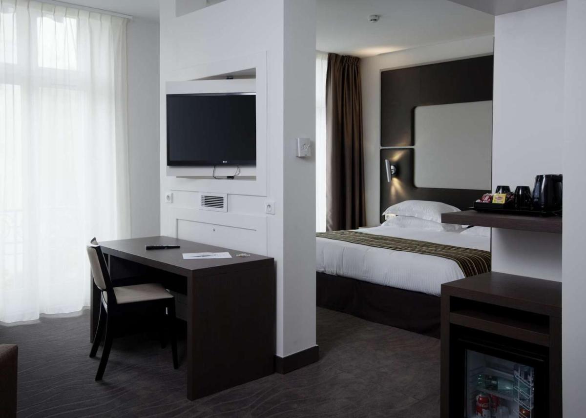 Un ou plusieurs lits dans un hébergement de l'établissement Brit Hotel de Grignan Vichy