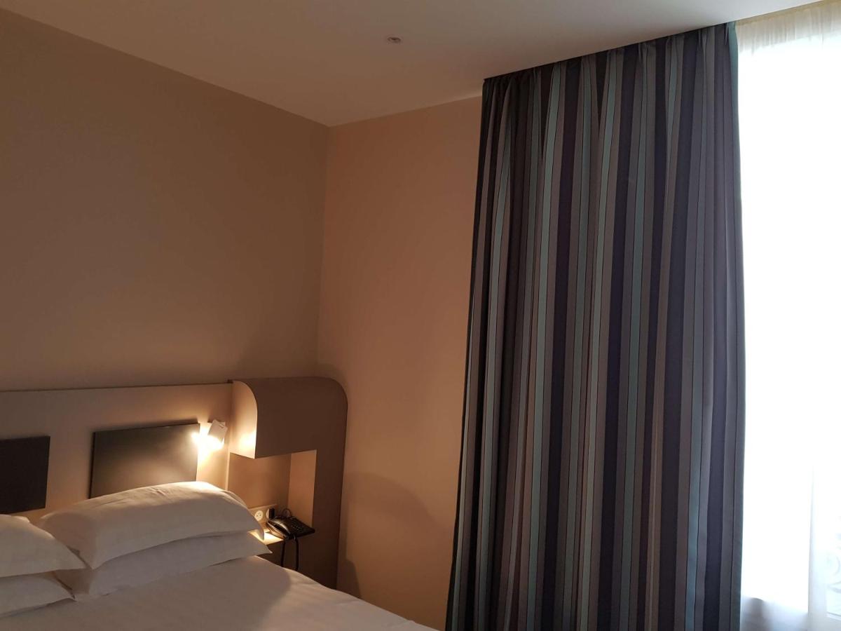 Un ou plusieurs lits dans un hébergement de l'établissement Brit Hotel de Grignan Vichy