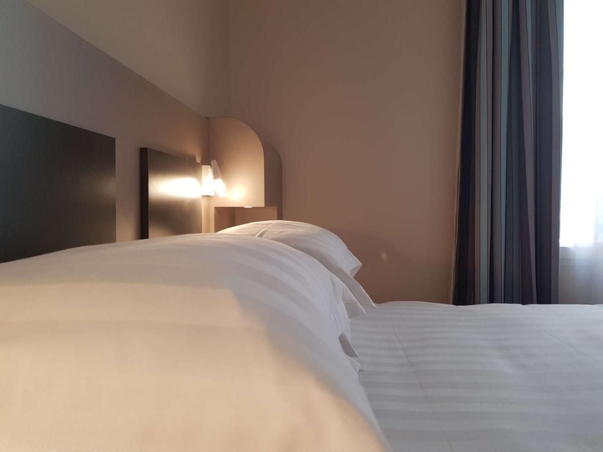 Un ou plusieurs lits dans un hébergement de l'établissement Brit Hotel de Grignan Vichy