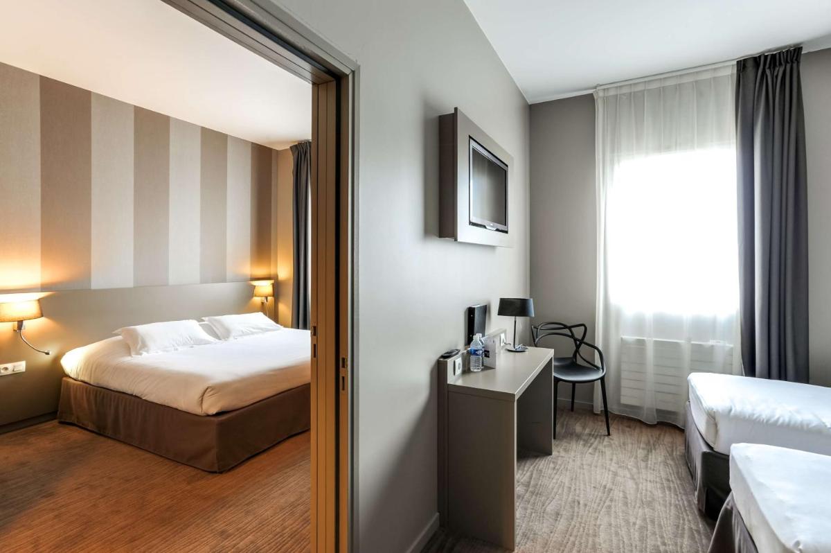 une chambre d'hôtel avec un lit et un miroir dans l'établissement Brit Hotel Le Galion & Spa, à Binic 35 autres photos