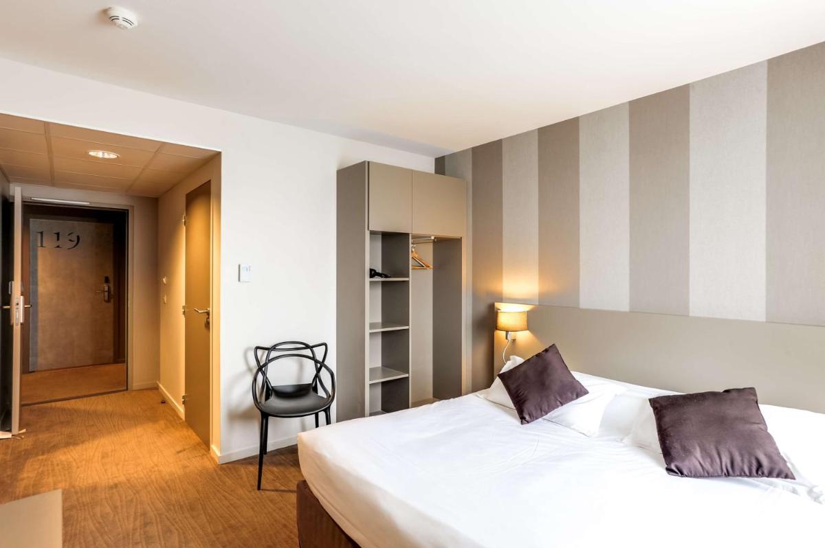 Un ou plusieurs lits dans un hébergement de l'établissement Brit Hotel Le Galion & Spa