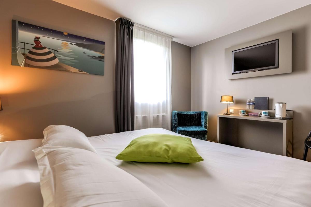 Un ou plusieurs lits dans un hébergement de l'établissement Brit Hotel Le Galion & Spa