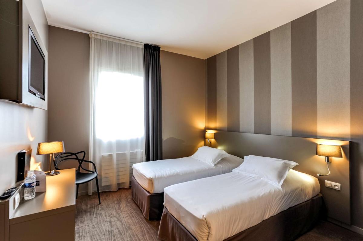 Un ou plusieurs lits dans un hébergement de l'établissement Brit Hotel Le Galion & Spa