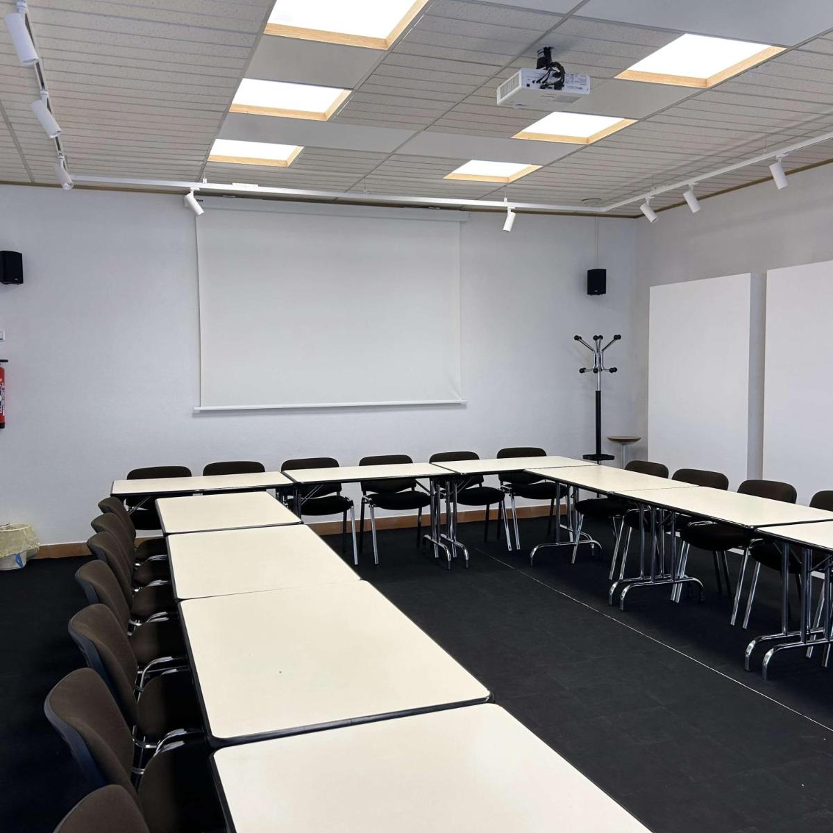une salle de conférence avec des tables et des chaises et un tableau blanc dans l'établissement BRIT HOTEL & SPA Le Roc au Chien, à Bagnoles-de-l'Orne 59 autres photos