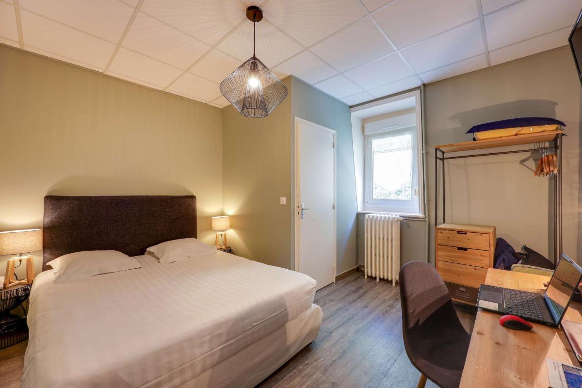 Un ou plusieurs lits dans un hébergement de l'établissement BRIT HOTEL & SPA Le Roc au Chien