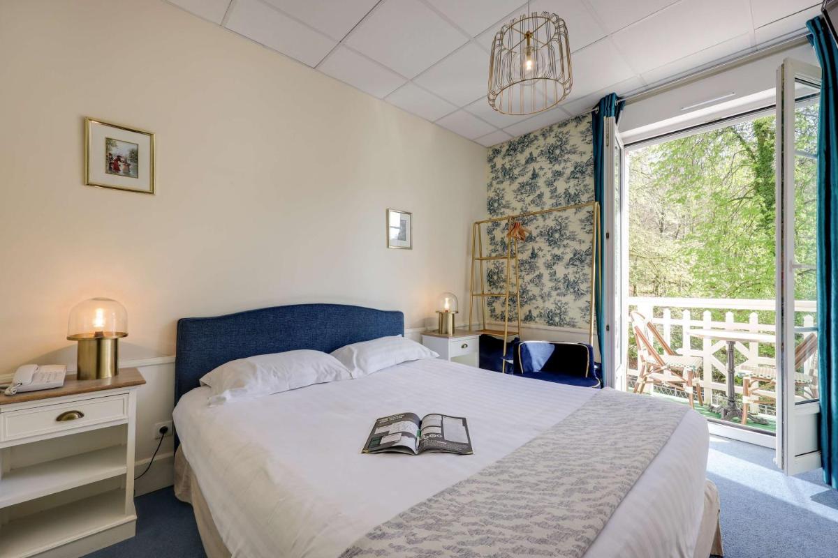 Un ou plusieurs lits dans un hébergement de l'établissement BRIT HOTEL & SPA Le Roc au Chien